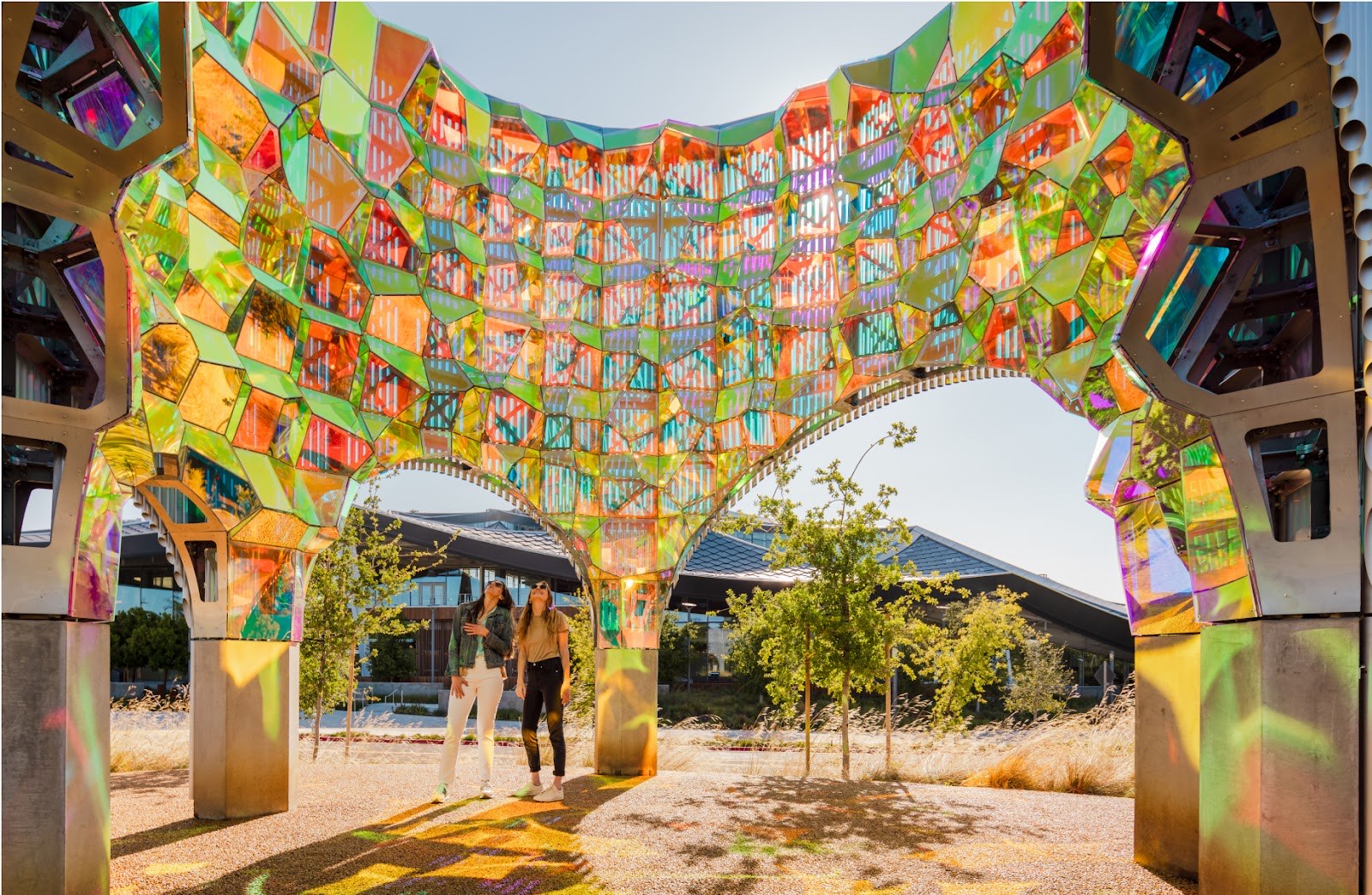 Visitors walking beneath Halo by SOFTlab — an iridescent dichroic-glass archway — at the Google Visitor Experience.