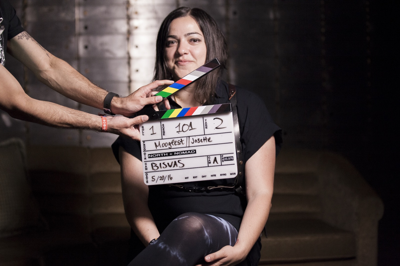 Portrait of Josette Melchor at Moogfest, a film clapperboard held in front of her.