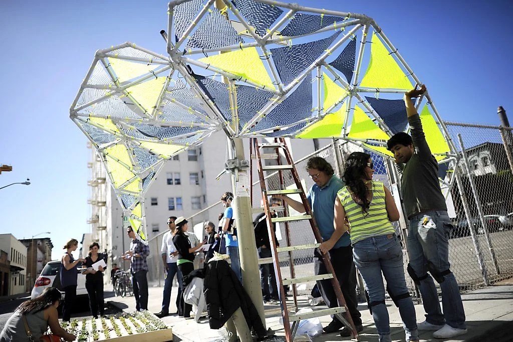 Participants assembling a lightweight tensile pavilion on a San Francisco street at the Urban Prototyping Festival.